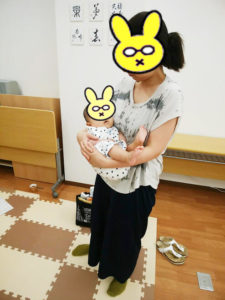 赤ちゃんを横抱っこするお母さん