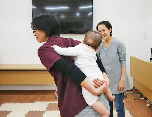 赤ちゃんをおんぶする田村