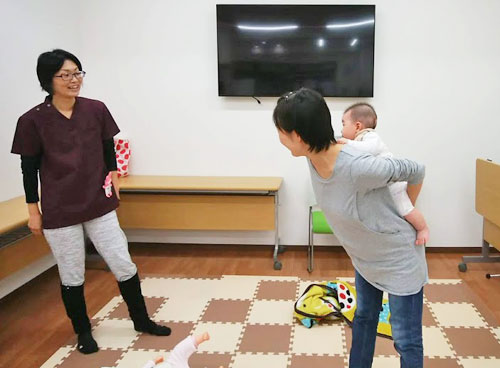お母さんがおんぶの練習をしているところ